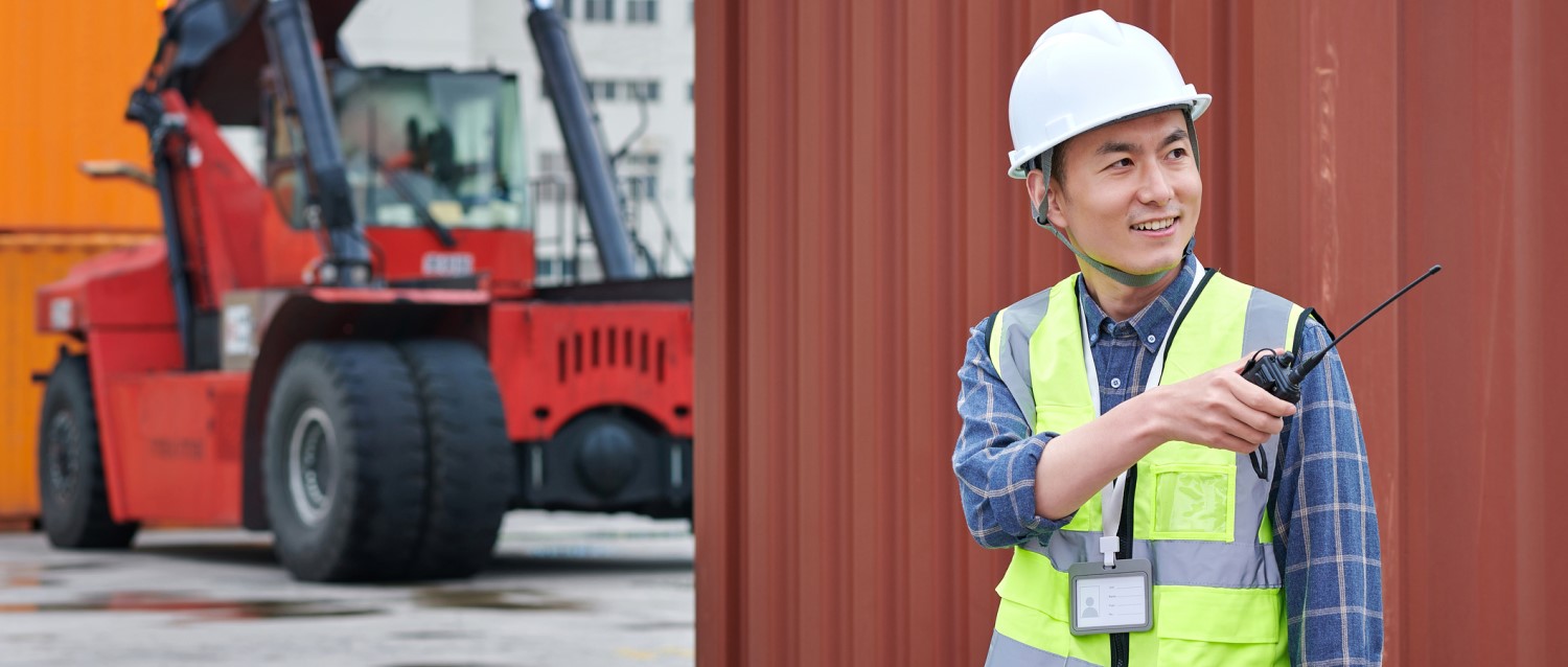 Lunar New Year Shipping: Shipyard worker with helmet and walkie talkie